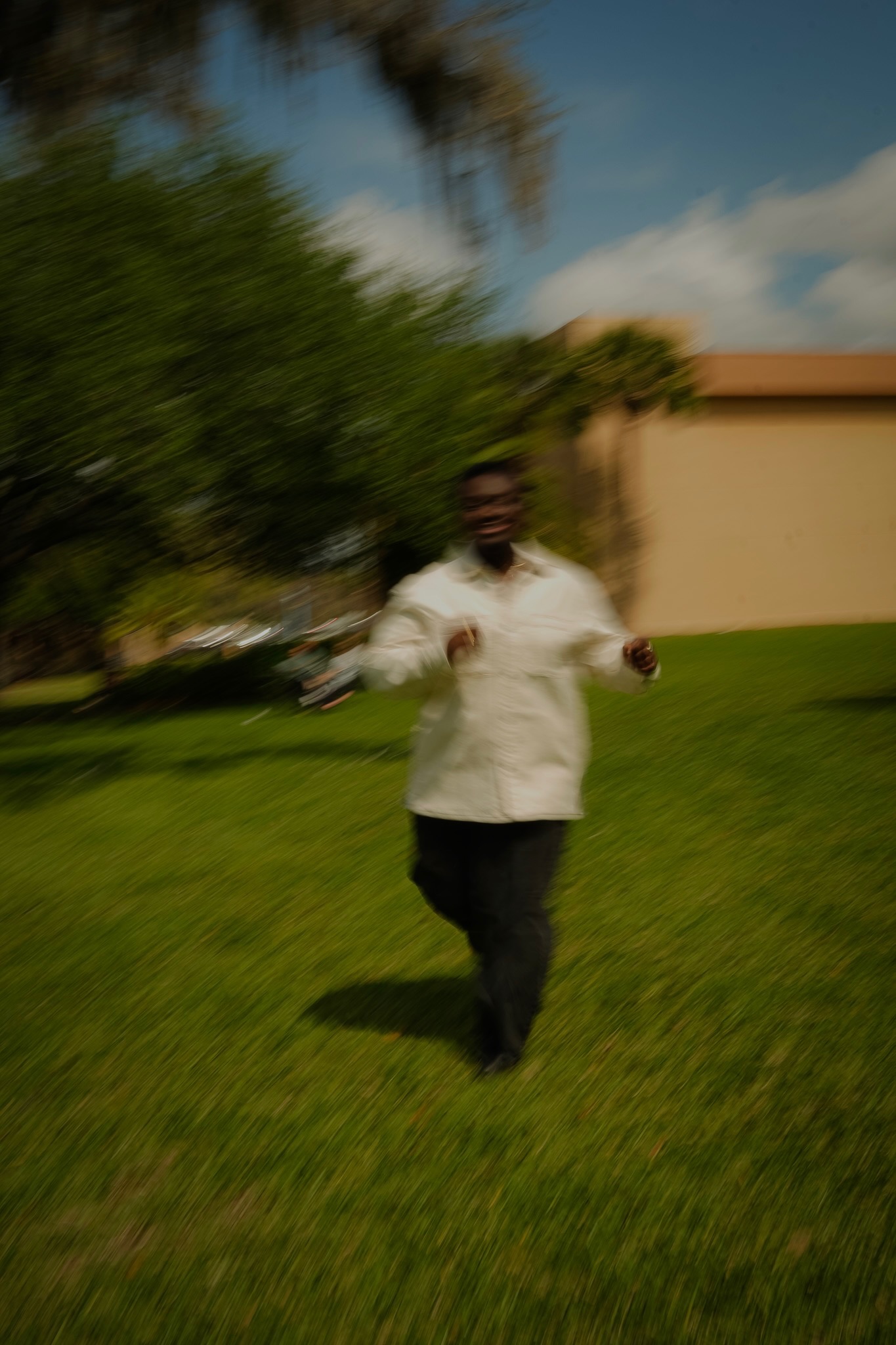 Joshua Burgess running on a sunlit lawn